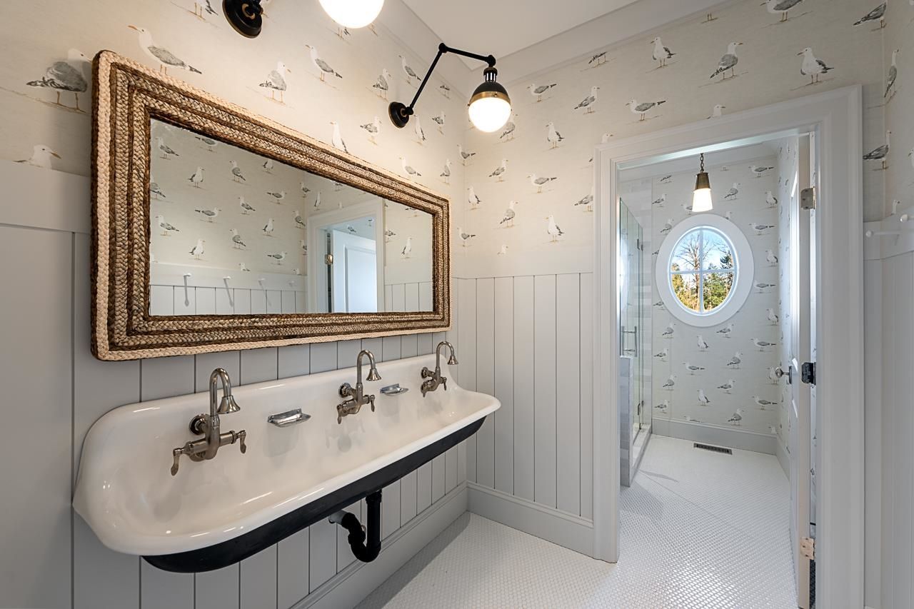 Grace Acres kids bathroom — seagull wallpaper, cast iron trough sink, porthole window, penny tile