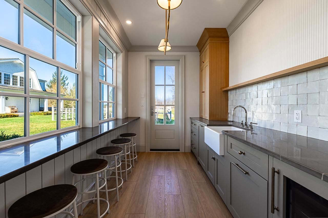 Grace Acres pool house bar kitchen — zellige tile backsplash, farmhouse sink, window bar seating
