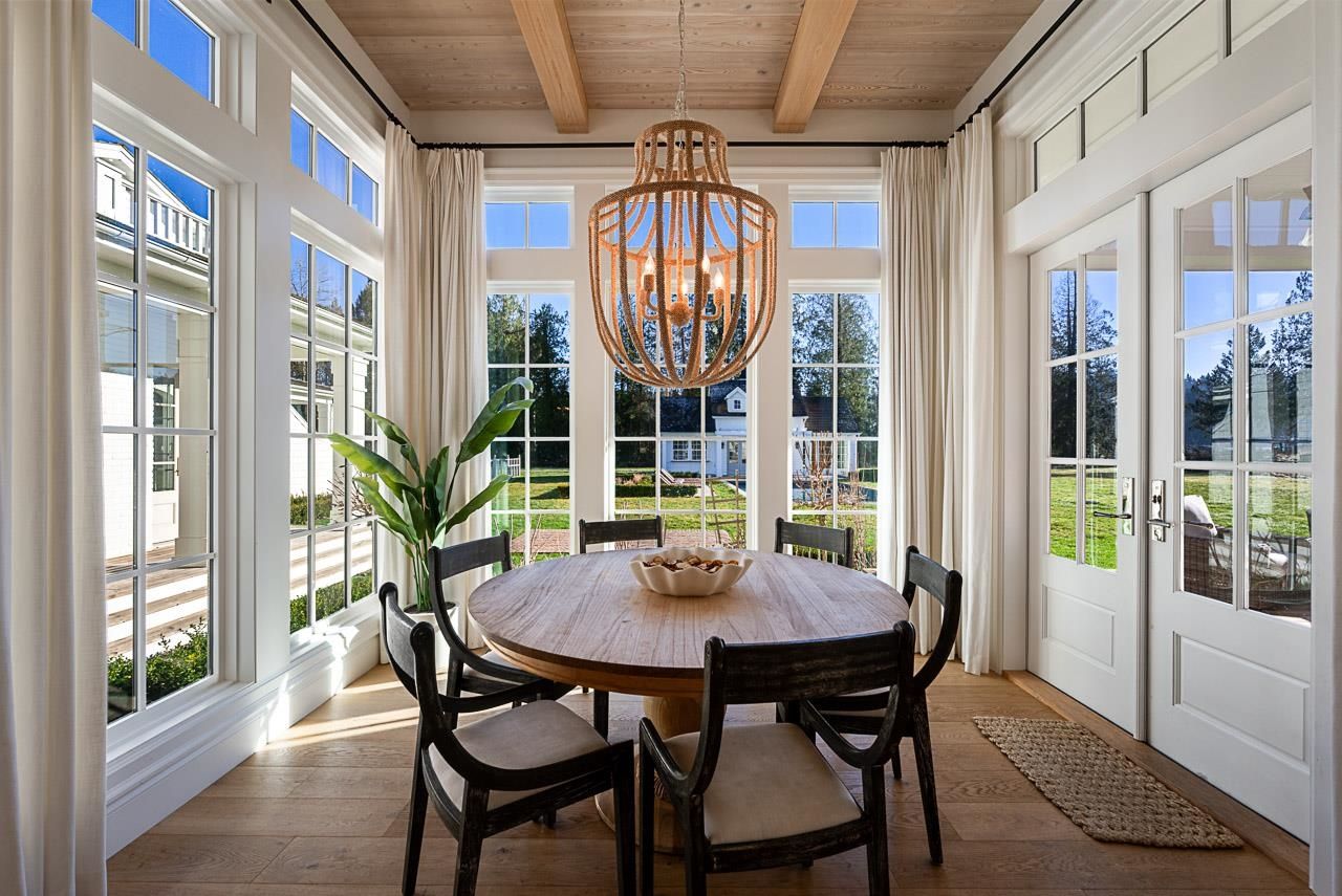 Grace Acres formal dining room — panelled walls, brass ring chandelier, cane back chairs
