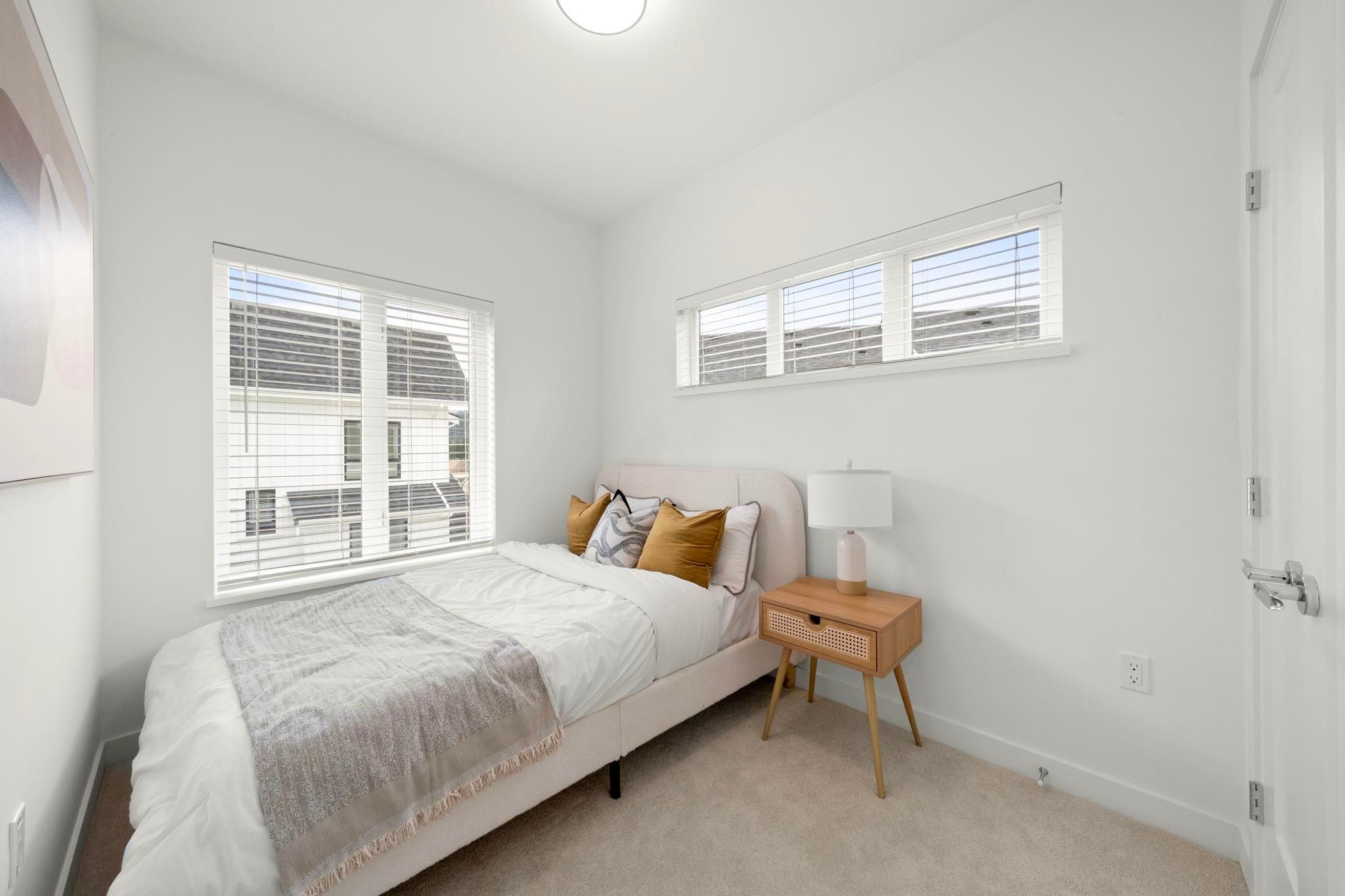 Secondary bedroom at 6-728 Lea Avenue with twin bed setup and large window