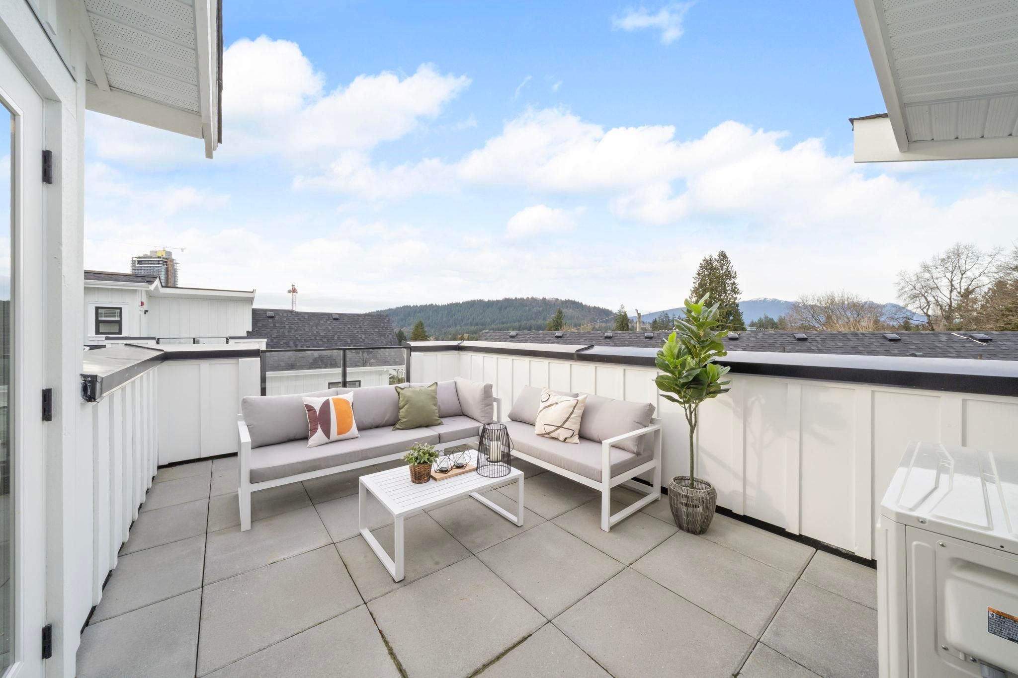 Rooftop patio at 6-728 Lea Avenue with outdoor sectional seating and a mountain view over the neighbouring rooftops