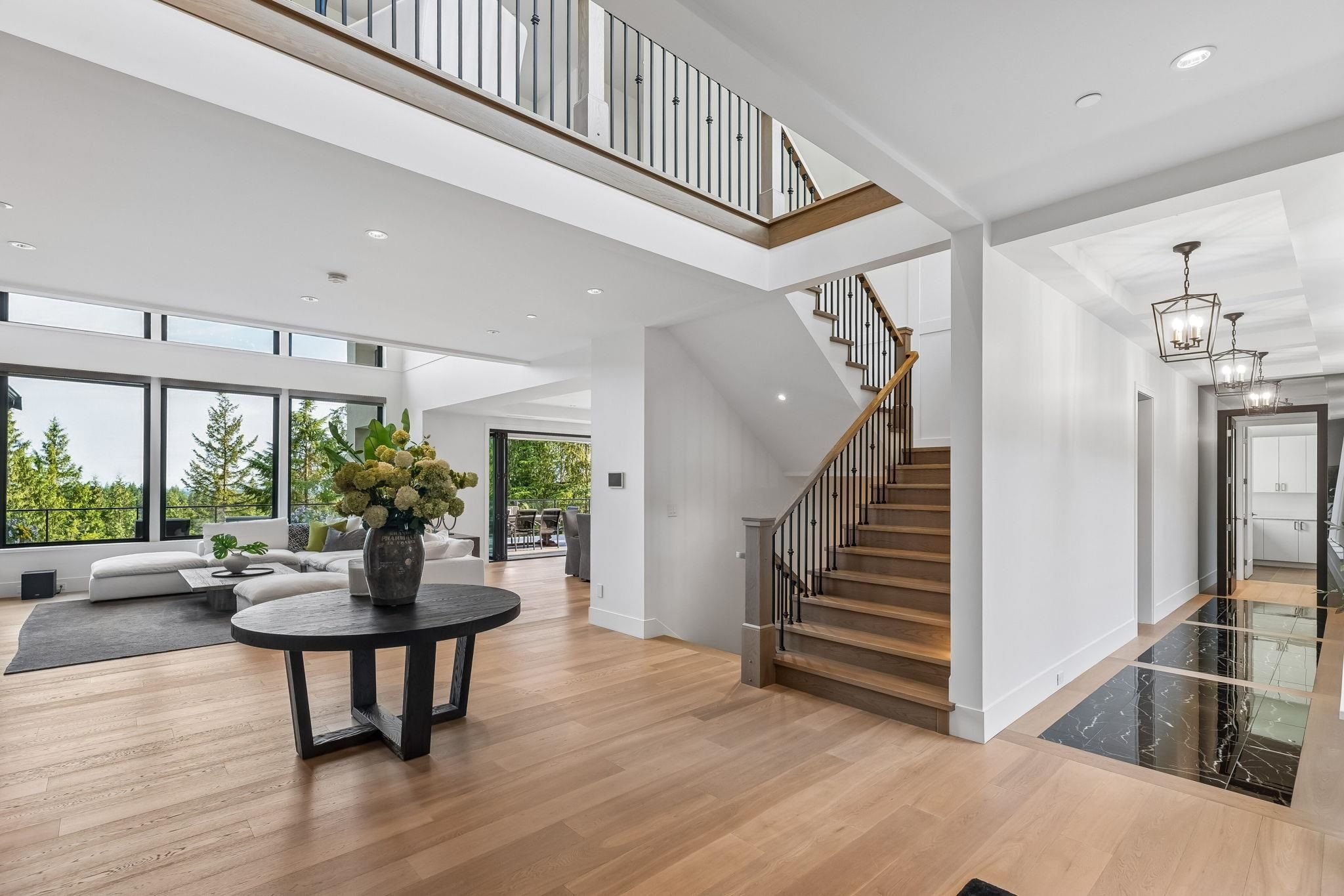 Open-concept foyer with floating staircase and vaulted ceiling at 2051 Ridge Mountain Drive, Anmore