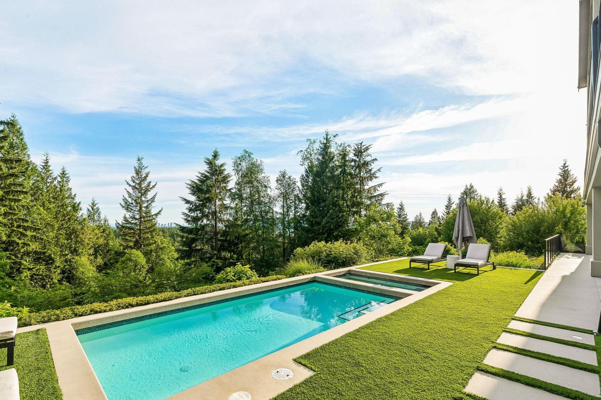 Outdoor pool with mountain and forest backdrop at 2051 Ridge Mountain Drive, Anmore