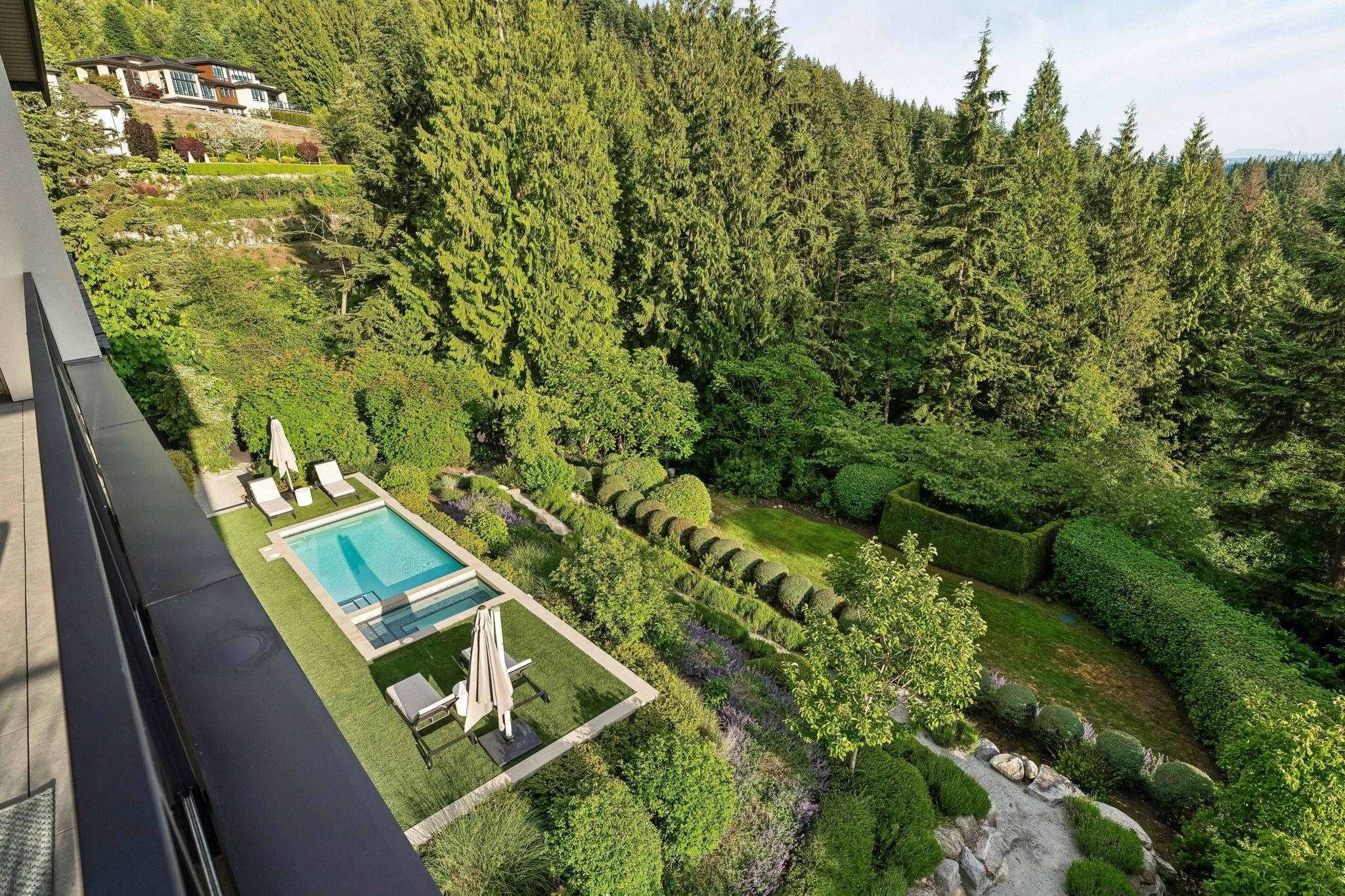 Aerial view of pool and forested one-acre lot from the upper patio at 2051 Ridge Mountain Drive, Anmore