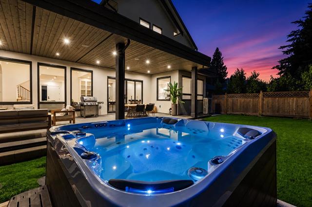 Backyard hot tub at dusk at 944 Caithness Crescent, Glenayre