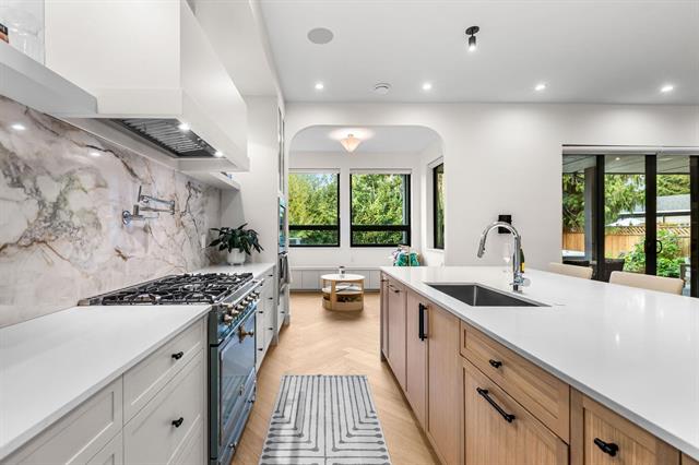 Chef's kitchen with La Cornue range and marble slab backsplash at 944 Caithness Crescent, Glenayre