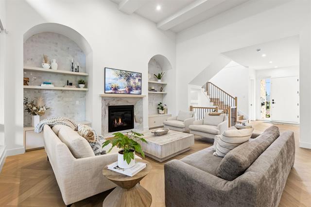 Great room with vaulted ceiling, fireplace and built-in shelving at Glenayre new-build home