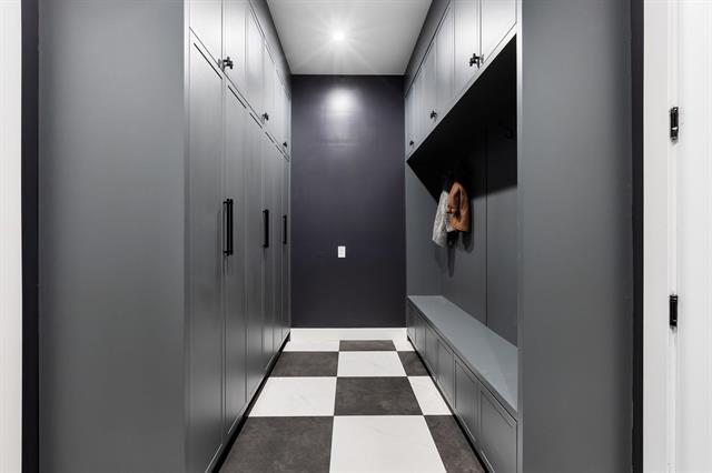 Mudroom with built-in lockers and tile flooring at 944 Caithness Crescent, Glenayre