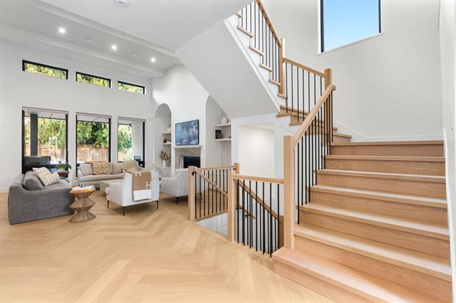 Open-concept foyer with floating staircase and vaulted ceiling at 944 Caithness Crescent, Glenayre