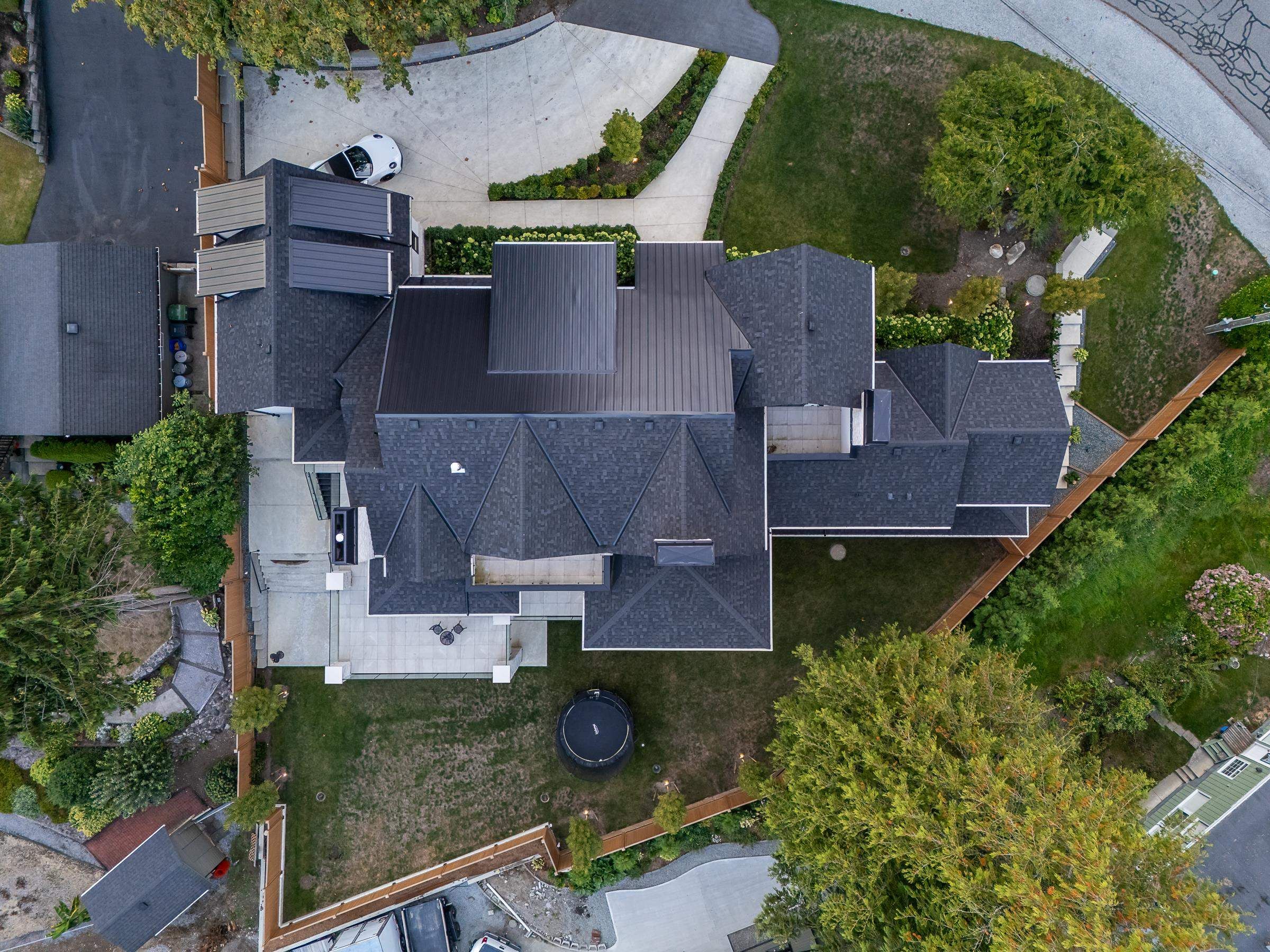 Aerial drone view of 2976 Lazy A Street showing the treed Ranch Park lot and mountain backdrop