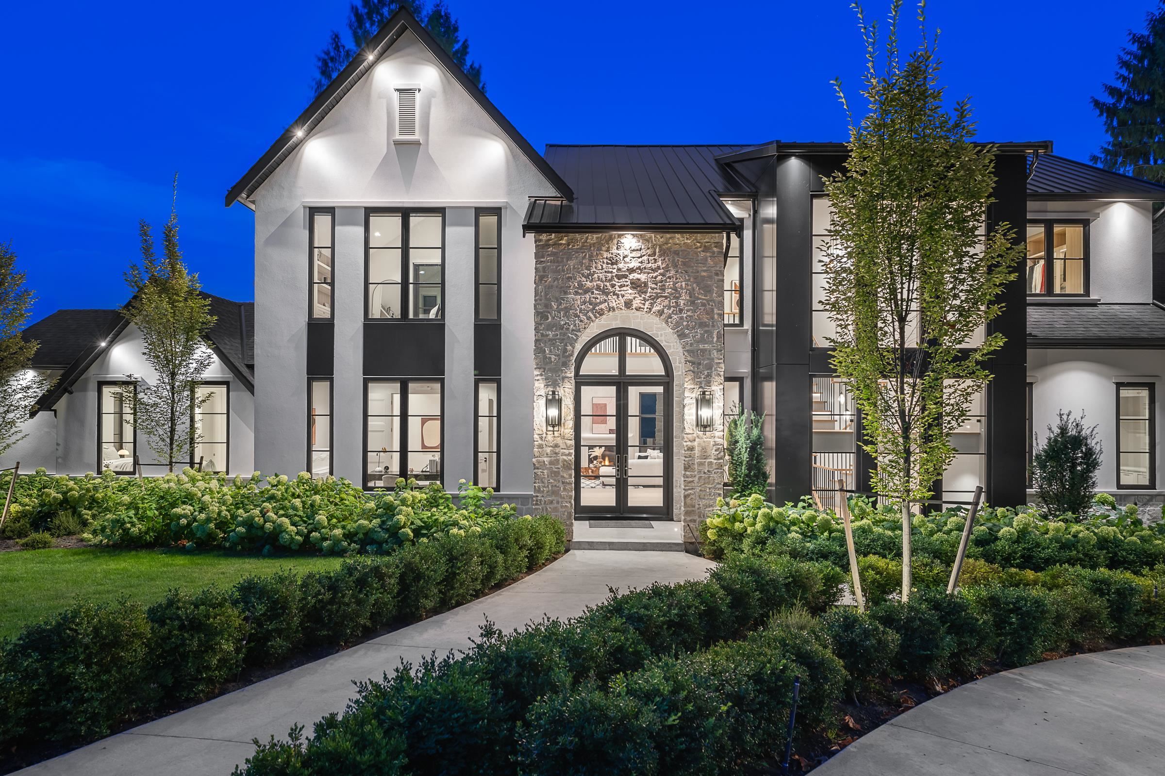 Daytime exterior view of the custom home at 2976 Lazy A Street showing stone and black steel facade