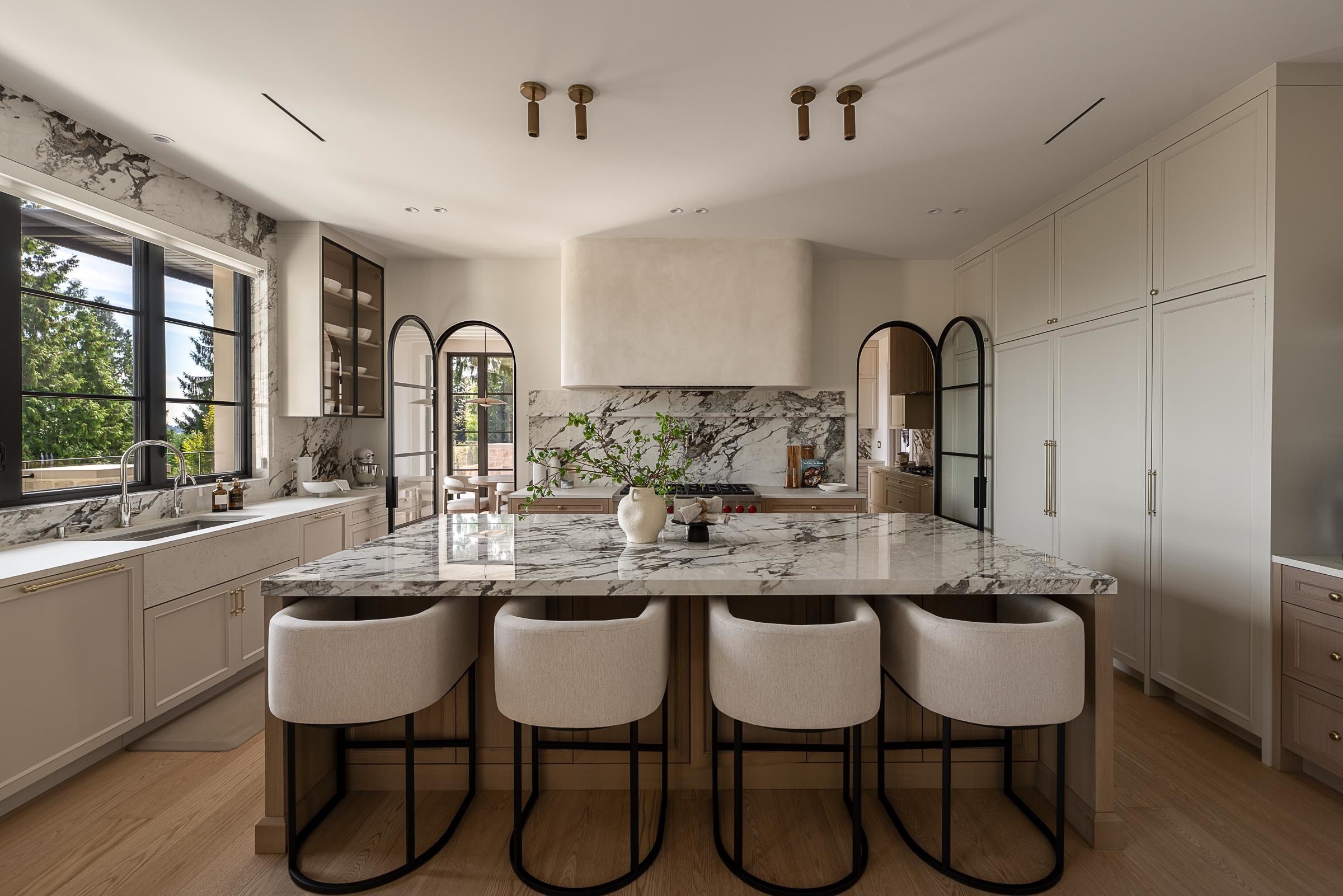 Kitchen island with waterfall marble countertop and upholstered stools at 2976 Lazy A Street, Ranch Park