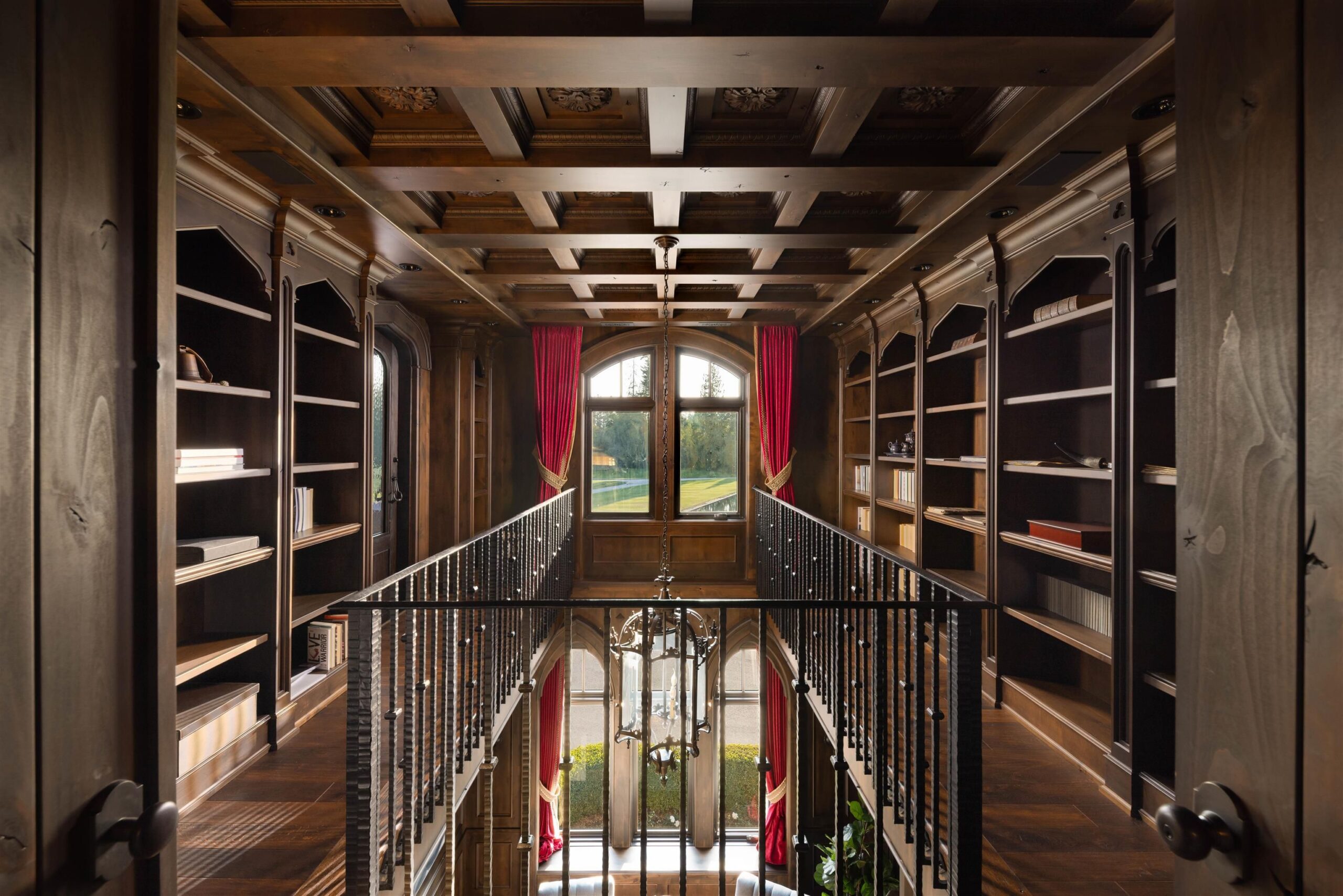 Library gallery with built-in shelving and bridge railing at Tannin Manor