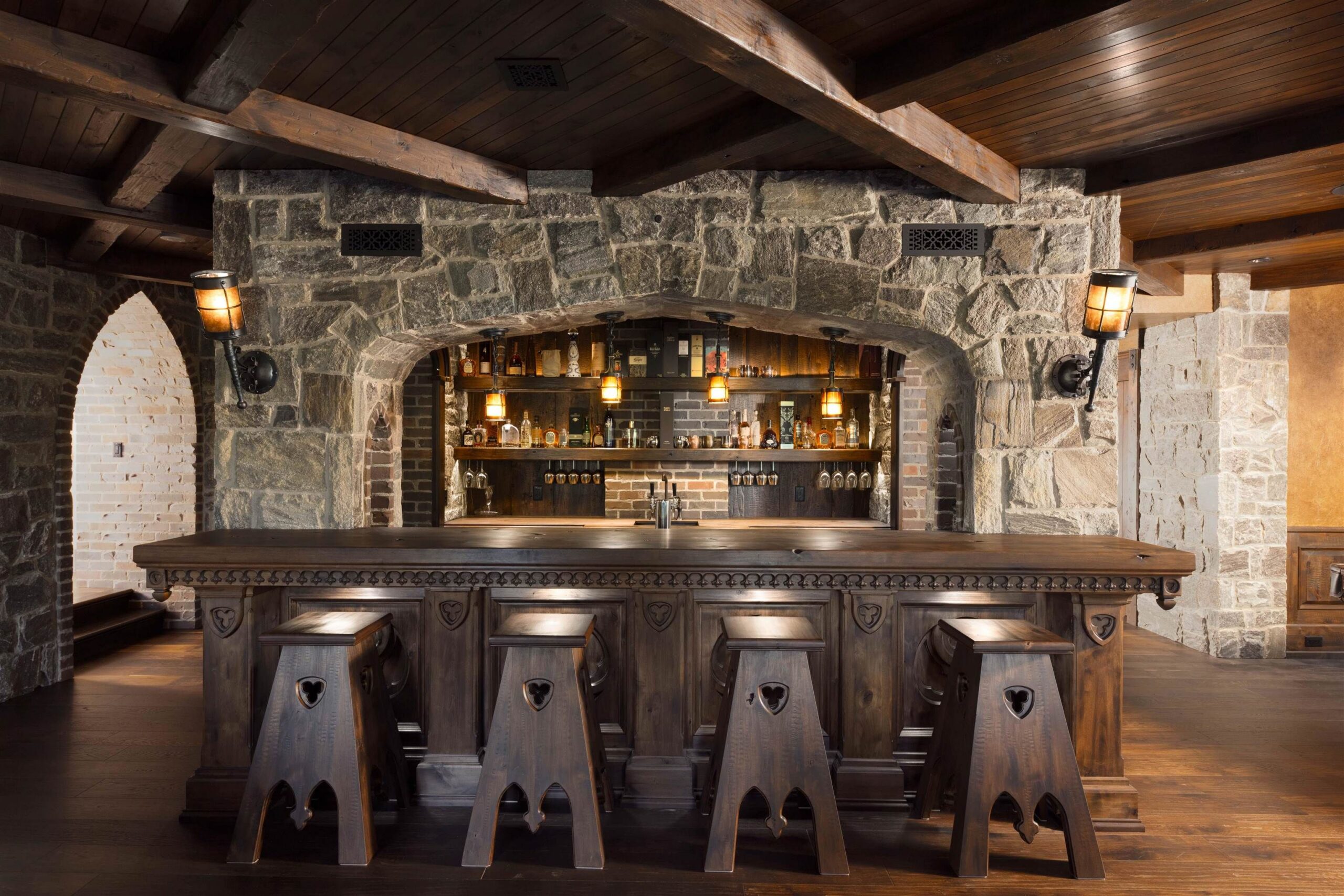 Stone-arched bar with timber stools in the Tannin Manor basement