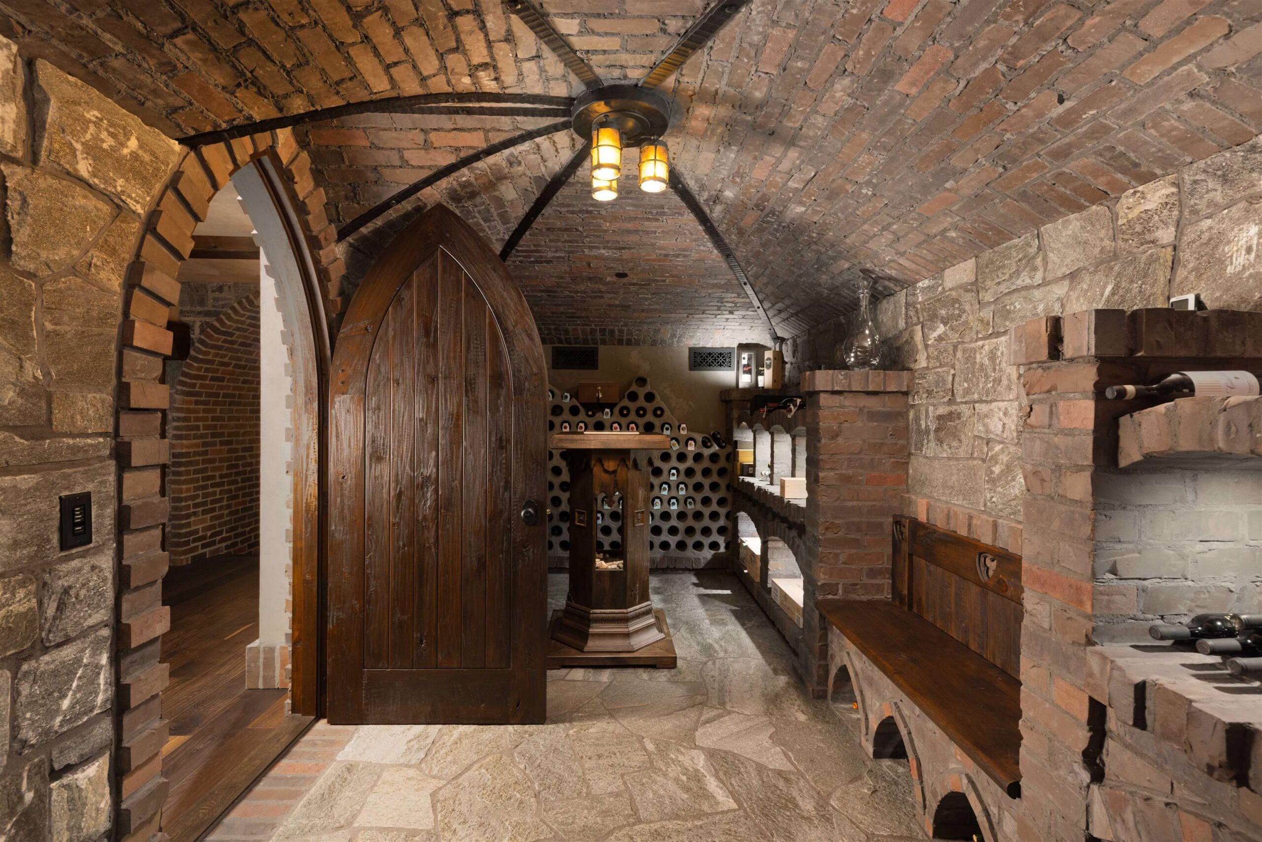Cave-style stone wine cellar with arched timber door at Tannin Manor
