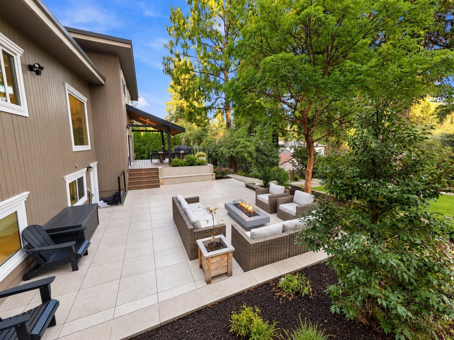 Landscaped backyard with patio and mature trees in Ranch Park Coquitlam